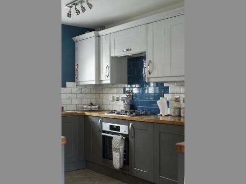 a kitchen with white cabinets and a stove top oven at The Case in Point in Witney