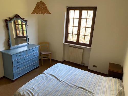 ein Schlafzimmer mit einer blauen Kommode und einem Spiegel in der Unterkunft Heerlijke villa met privé zwembad & 5 slaapkamers dicht bij Lucca en Pisa in Monsagrati