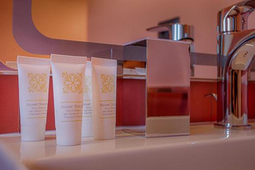a group of four bottles of sunscreen on a kitchen counter at Le Canterine di Peppe in Ascoli Piceno