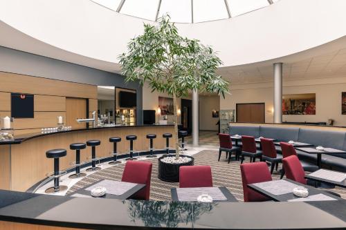 a restaurant with tables and chairs and a bar at Mercure Hotel Frankfurt Eschborn Süd in Eschborn