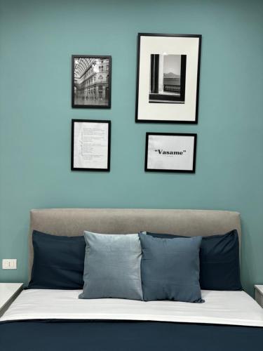 una camera da letto con una parete blu e immagini sopra un letto di Salotto Mariella a Napoli