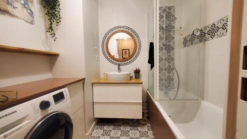 a bathroom with a sink and a washing machine at Grand appartement avec jardin calme et lumineux in Saint-Ouen