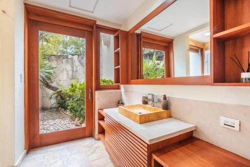 a bathroom with a sink and a window at Amazing 5br villa w pool at Green Village A in Punta Cana