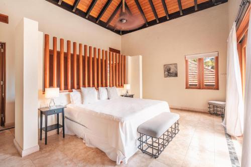 a bedroom with a large white bed and a window at Amazing 5br villa w pool at Green Village A in Punta Cana