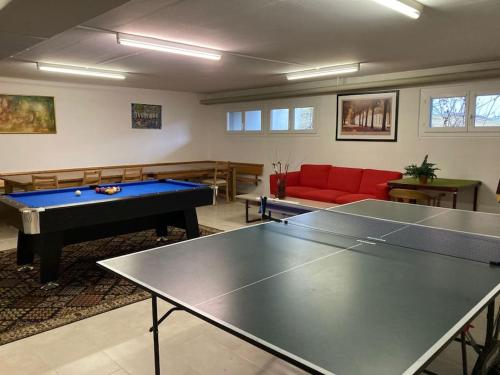 a living room with ping pong tables and a red couch at Gemütliches Bergidyll mit top Lage in Leukerbad