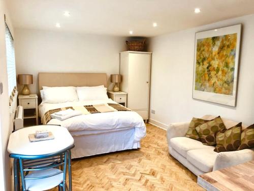una camera da letto con un letto e un divano di Charming studio suite minimum 2 night stay a Southwick