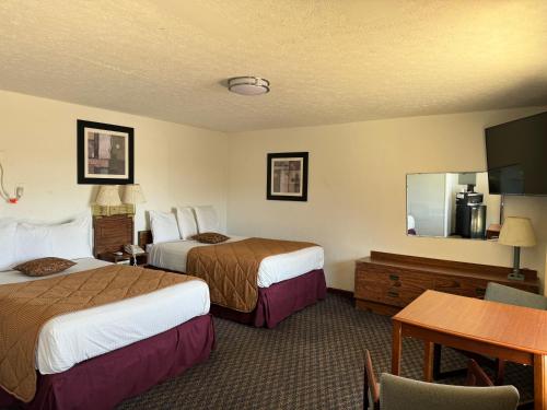 een hotelkamer met 2 bedden en een tafel bij Royal Inn in Albany