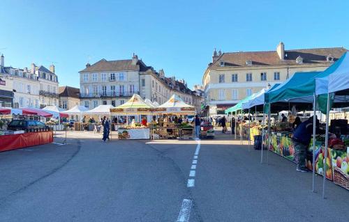 an open air market in a city with many stalls at Terre de Bourgogne - Appartement au centre ville d'Avallon in Avallon