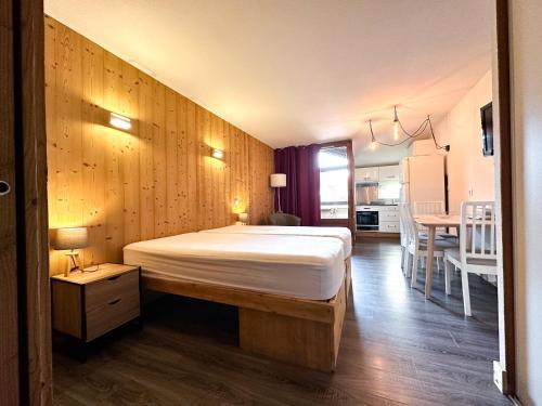 - une chambre avec un lit et un mur en bois dans l'établissement 2- Studio Brides-les-bains tout confort avec vue Vanoise, à Brides-les-Bains