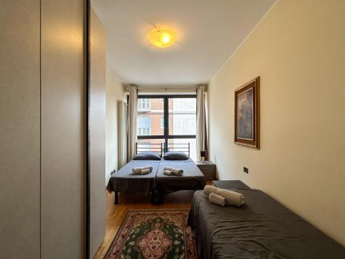 a small bedroom with two beds and a window at [Esclusivo 120 MQ] nel cuore di Bergamo in Bergamo