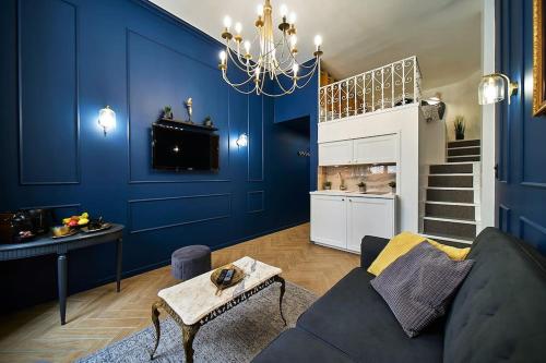 un salon bleu avec un canapé et une table dans l'établissement Duguesclin Baroque / appartement de charme, à Lyon