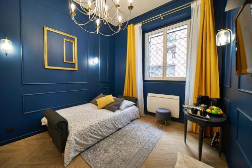 une chambre bleue avec un lit et une fenêtre dans l'établissement Duguesclin Baroque / appartement de charme, à Lyon