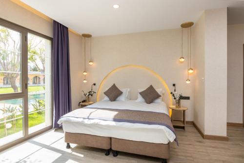 een slaapkamer met een groot bed en een groot raam bij Ema Houses in Antalya