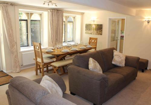 a living room with a couch and a dining room table at Springfield Coach House - Leisure and Business travellers in Stroud