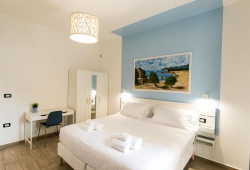 ロッサーノにあるBorgo Sant'Angelo Apartmentの大きな白いベッドと机のある寝室