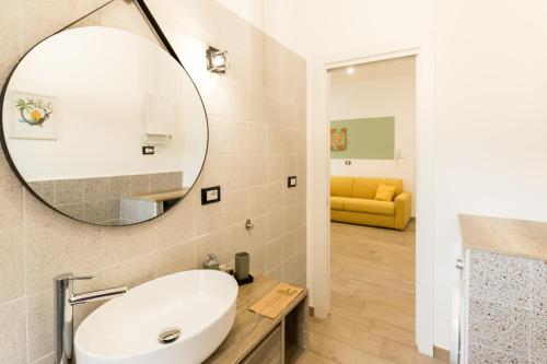 ein Bad mit einem Waschbecken und einem Spiegel in der Unterkunft Borgo Sant'Angelo Apartment in Rossano