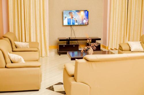 uma sala de estar com duas cadeiras e uma televisão em Dodoma furnished Apartment em Dodoma