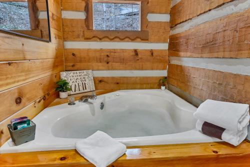 a bathroom with a tub in a wooden house at Wildwood Cottage in Townsend