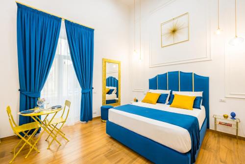 een blauwe en witte slaapkamer met een bed en een tafel bij L'Angolo d'o core in Napels