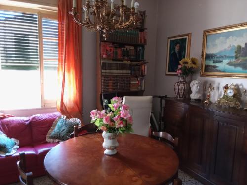 una sala de estar con una mesa con flores. en Centro Storico House, en Palermo