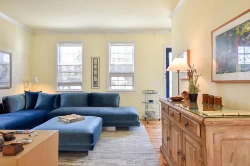 a living room with a blue couch and a table at NEW AC 1 Bedroom w Private Deck & Patio in Provincetown