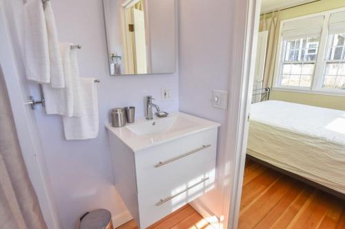 uma casa de banho branca com um lavatório e uma cama em NEW AC 1 Bedroom w Private Deck & Patio em Provincetown