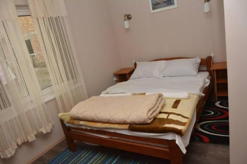 a bed sitting in a room with a window at Etno Kuca Paor-apartmani in Kikinda