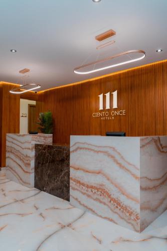 a lobby with a counter with a sign on a wall at Hotels 111 in San Andrés