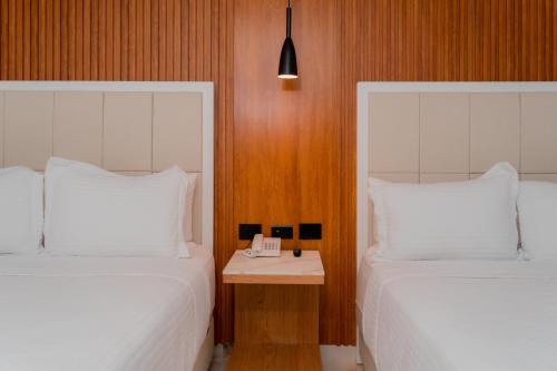 una habitación de hotel con 2 camas y un teléfono en una mesa en Hotels 111, en San Andrés