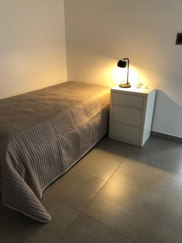 a bedroom with a bed and a lamp on a night stand at Lo de Chany in San Juan
