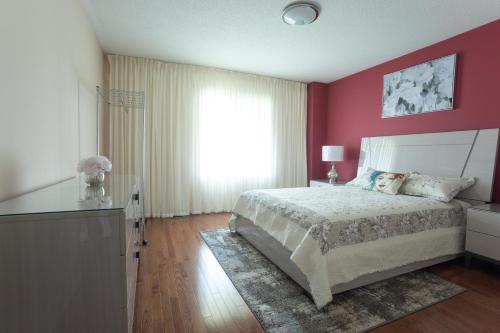 a bedroom with a large bed and a window at Main Floor Luxury Apartment in Vaughan