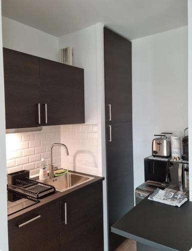 une cuisine avec un évier et un plan de travail dans l'établissement Issy-les-Moulineaux : Studio rénové, à Issy-les-Moulineaux