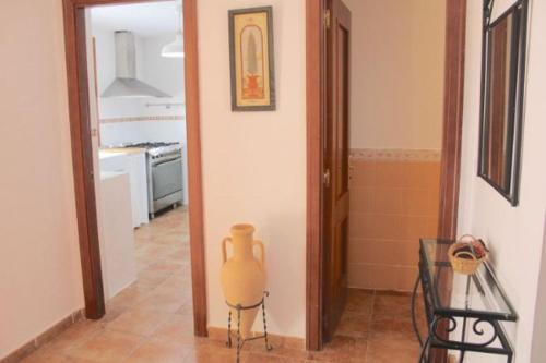 a kitchen with a vase in the middle of a hallway at ACOGEDOR ADOSADO DE ESQUINA. LAS LOMAS. JUNTO AL ALGARVE PORTUGUÉS. in Huelva