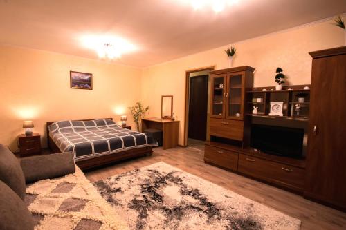 a bedroom with a bed and a tv and a couch at Nadezhda Apartments at Kabanbay Batyr 79 in Almaty