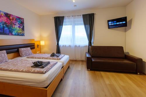 a hotel room with a bed and a couch at Flataid Apartments Marienbrau in Hart bei Graz