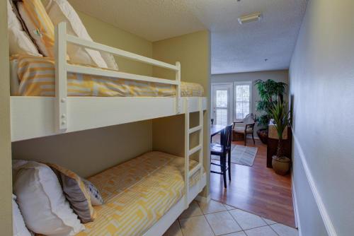 1 Schlafzimmer mit 2 Etagenbetten und einem Esszimmer in der Unterkunft Grand Caribbean East 209 in Destin