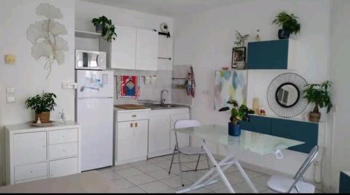 une cuisine avec une table et un réfrigérateur blanc dans l'établissement Logement entier - Les Baumettes, à Nice