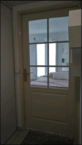 une porte avec une fenêtre et un lit dans une chambre dans l'établissement Logement entier - Les Baumettes, à Nice