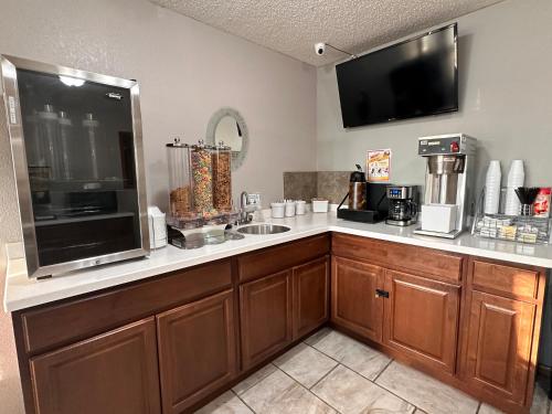 a kitchen with a counter with a sink and a tv at Super 8 by Wyndham Smithville Kansas City in Smithville