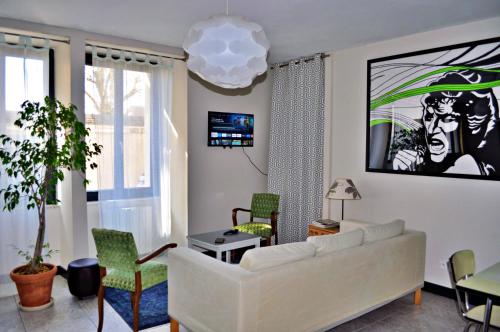 a living room with a white couch and chairs at Appt 56m2 à 4mn du Palais Jacques Coeur. in Bourges
