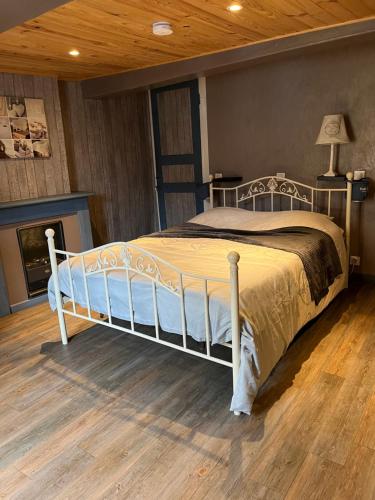 ein weißes Bett in einem Schlafzimmer mit Holzboden in der Unterkunft Gîte Pierre et Meuse in Fumay