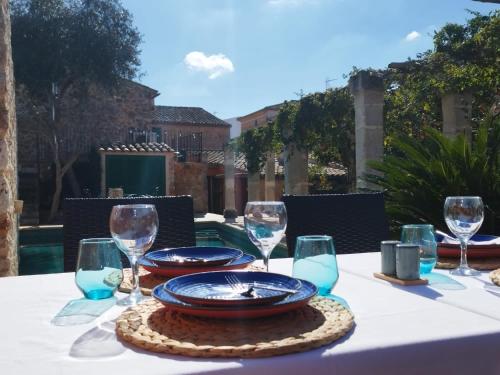 a table with a white table cloth with a plate and wine glasses at PETIT HOTEL ALGAIDA in Algaida