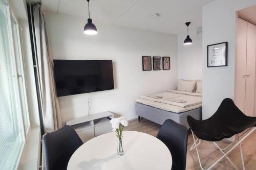 Habitación con mesa, sillas y cama en Lovely new studio for 3 - close to airport, free parking, en Vantaa