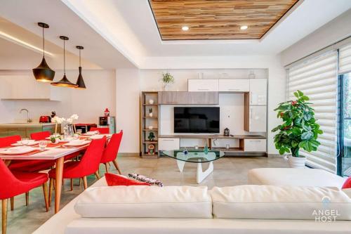 a living room with a table and red chairs at Condo with Amenities Sleeps 8 Roof Pool Gym in Playa del Carmen