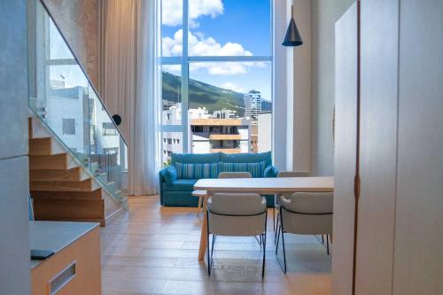 GO Quito Hotel في كيتو: غرفة معيشة مع طاولة وكراسي وأريكة