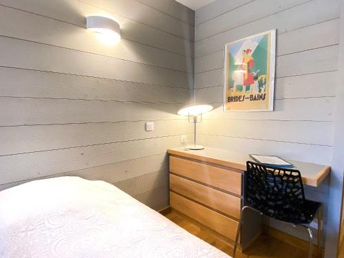 ein Schlafzimmer mit einem Bett und einem Schreibtisch mit einer Lampe in der Unterkunft 3- Charmant studio Brides-les-Bains in Brides-les-Bains