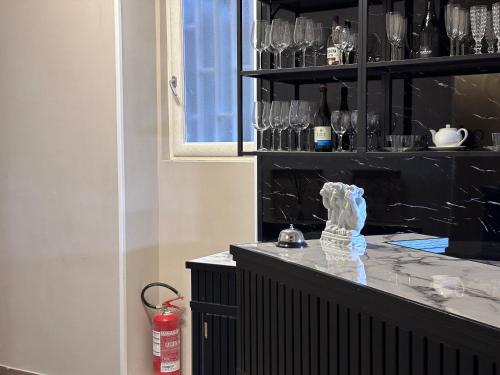 a black counter with glasses on a shelf at Parthenope Rooms in Naples