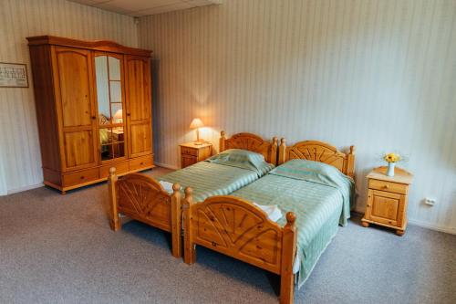 um quarto com uma cama de madeira e um armário em Naukšēnu muiža em Naukšēni