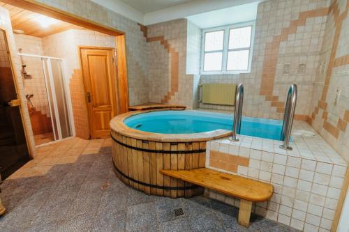 a large bathroom with a tub with a wooden bench at Naukšēnu muiža in Naukšēni