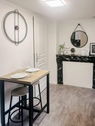 une salle à manger avec une table et une cheminée dans l'établissement Le Milano - Studio Centre ville - Romans, à Romans-sur-Isère